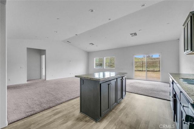 222 Garden Air Ct, Calimesa, CA 92320 - kitchen featuring visible vents, light wood-style flooring, light colored carpet, open floor plan, and a center island
