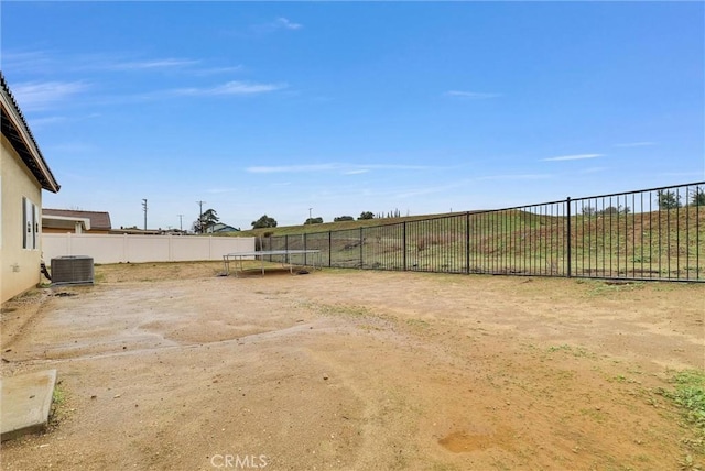 222 Garden Air Ct, Calimesa, CA 92320 - view of yard with central air condition unit, a trampoline, and a fenced backyard