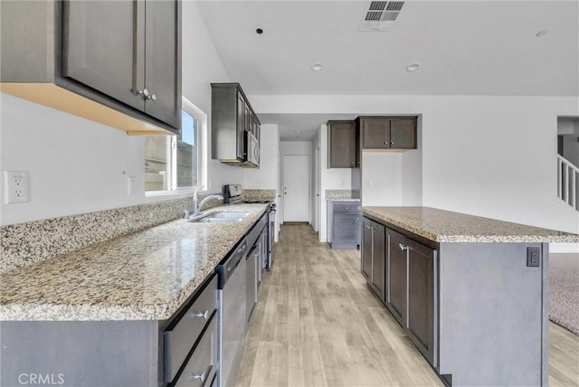 222 Garden Air Ct, Calimesa, CA 92320 - kitchen featuring visible vents, light wood-style flooring, a kitchen island, stainless steel appliances, and dark brown cabinets
