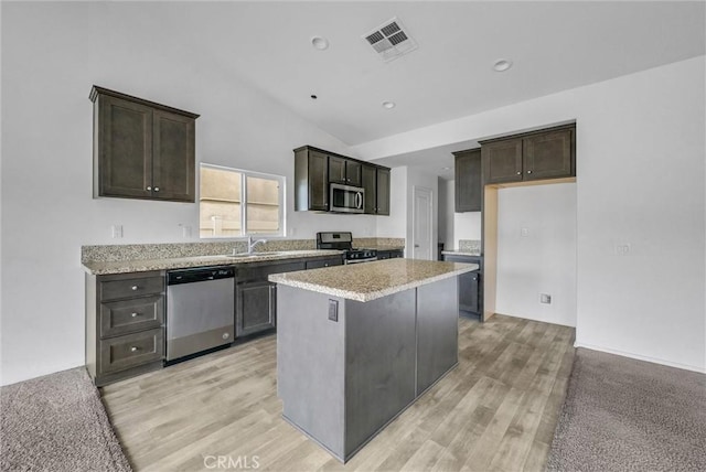 222 Garden Air Ct, Calimesa, CA 92320 - kitchen with visible vents, a kitchen island, stainless steel appliances, dark brown cabinetry, and light wood-type flooring
