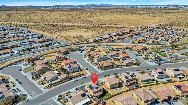 birds eye view of property featuring a desert view, a mountain view, and a residential view