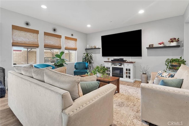 living room with recessed lighting, baseboards, wood finished floors, and a fireplace