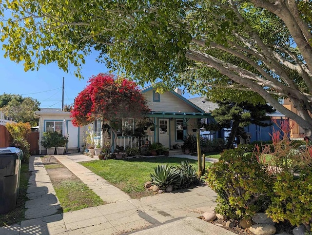 view of front of home featuring a porch, a front yard, and fence