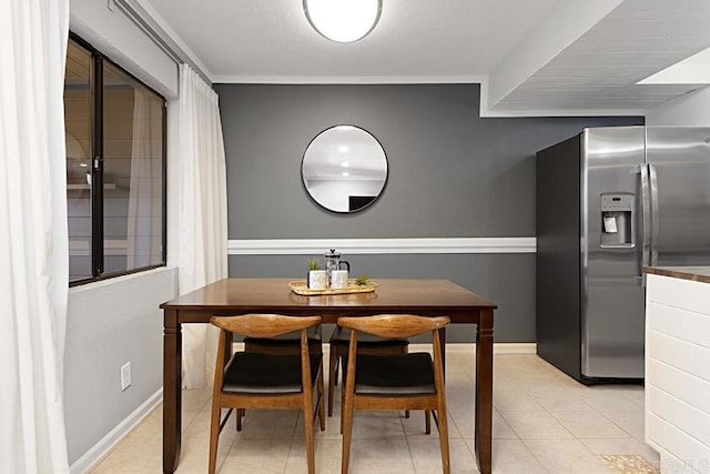 dining area featuring light tile patterned floors and baseboards