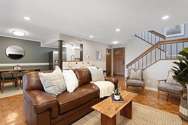 living room with visible vents, recessed lighting, a textured ceiling, and stairs