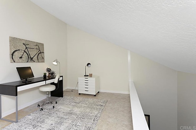 office with vaulted ceiling, baseboards, and a textured ceiling