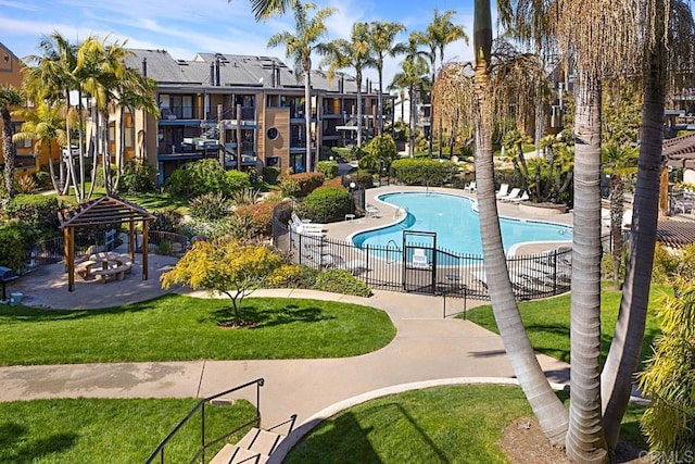 community pool featuring a gazebo, a lawn, and fence