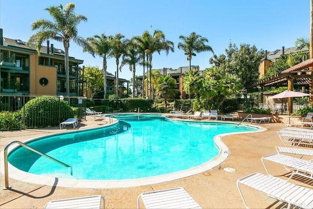 community pool featuring a patio area and fence