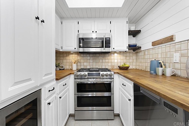 kitchen featuring open shelves, light tile patterned flooring, stainless steel appliances, decorative backsplash, and butcher block countertops