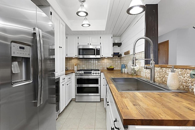 kitchen with a sink, wooden counters, backsplash, and appliances with stainless steel finishes