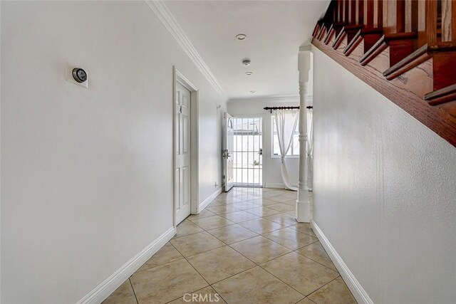 hallway featuring light tile patterned flooring, stairway, baseboards, and ornamental molding