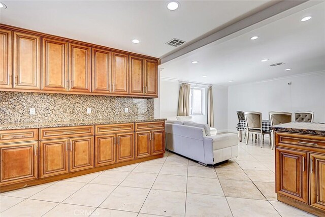 kitchen with visible vents, brown cabinets, and open floor plan
