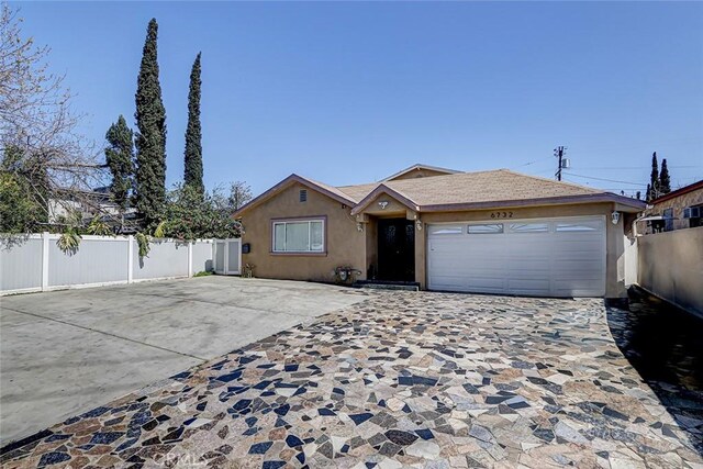 single story home featuring stucco siding, driveway, a garage, and fence