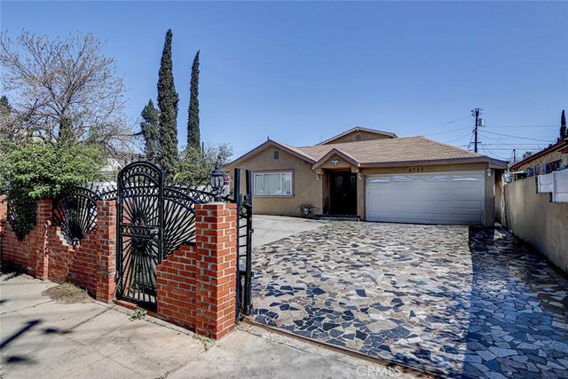 single story home featuring stucco siding, a gate, fence, concrete driveway, and an attached garage
