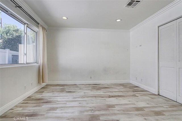 spare room with wood finished floors, baseboards, visible vents, recessed lighting, and ornamental molding