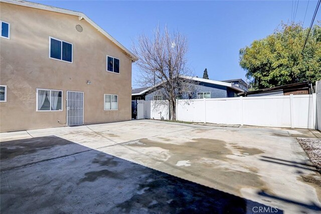 exterior space with stucco siding, a fenced backyard, and a patio area