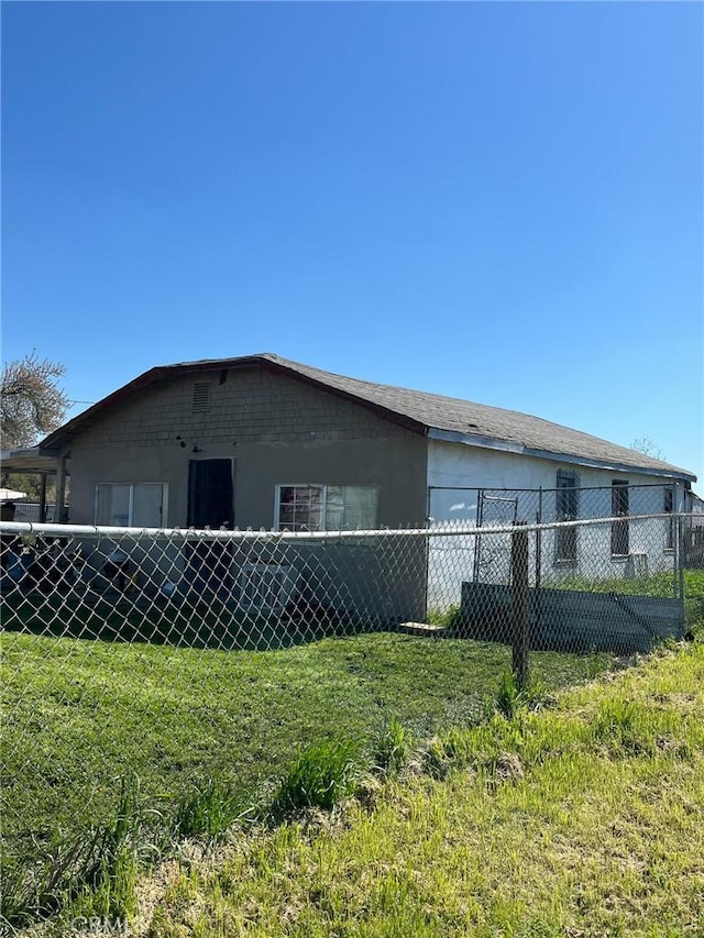 back of house featuring a yard and fence