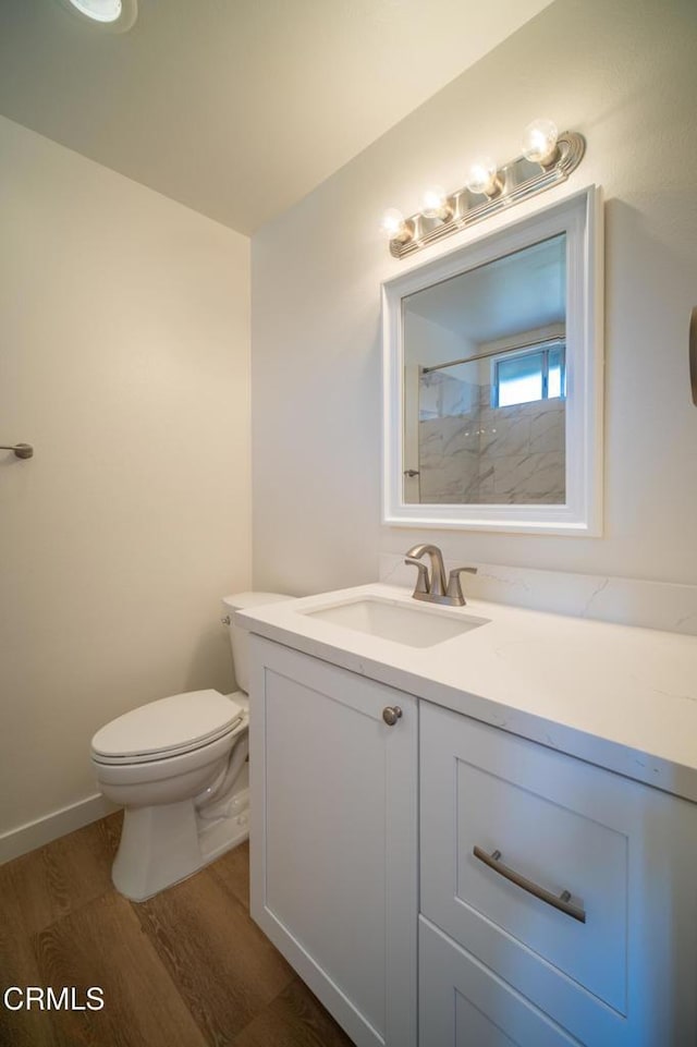 full bath featuring vanity, toilet, wood finished floors, and walk in shower