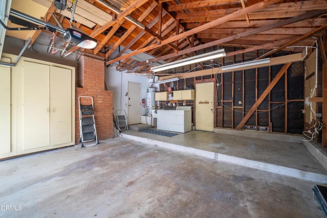 garage featuring strapped water heater, independent washer and dryer, and a garage door opener