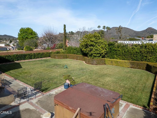 view of yard featuring a mountain view, a patio, and a hot tub