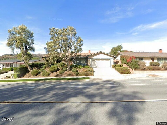 ranch-style home featuring a garage and concrete driveway