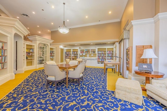 carpeted living area with built in shelves, visible vents, a towering ceiling, and ornamental molding