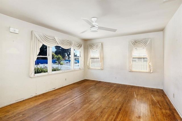 empty room with a ceiling fan and hardwood / wood-style flooring