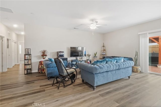 living area featuring light wood-style flooring and ceiling fan