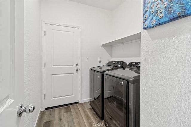 laundry room featuring laundry area, separate washer and dryer, and light wood-type flooring