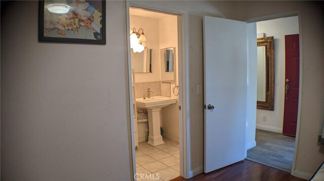 corridor featuring baseboards and wood finished floors