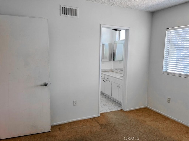 bathroom with a textured ceiling, visible vents, vanity, and plenty of natural light