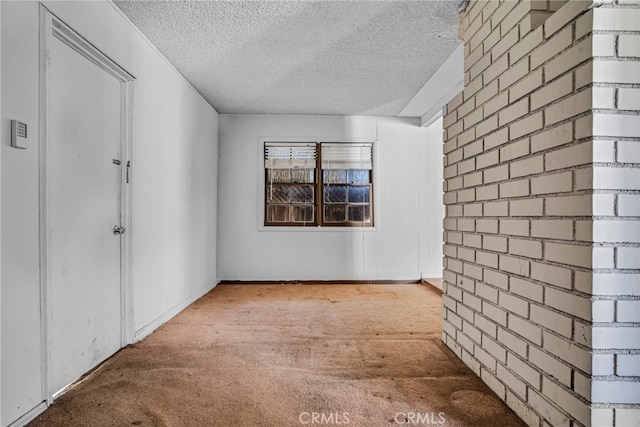 unfurnished room with a textured ceiling and carpet