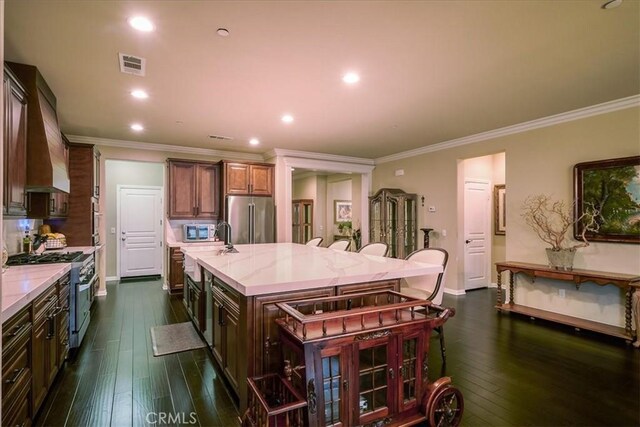 30459 Cowboy Ln, Menifee, CA 92584 - kitchen featuring stainless steel appliances, a spacious island, ornamental molding, dark wood-style flooring, and custom exhaust hood