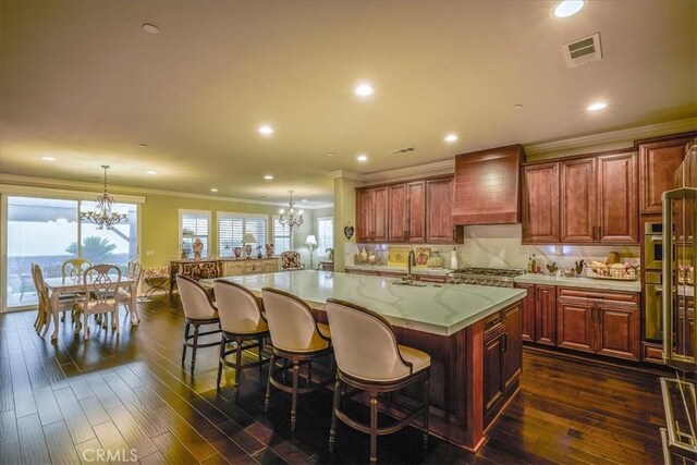 30459 Cowboy Ln, Menifee, CA 92584 - kitchen featuring a chandelier, custom range hood, crown molding, a kitchen bar, and dark wood finished floors