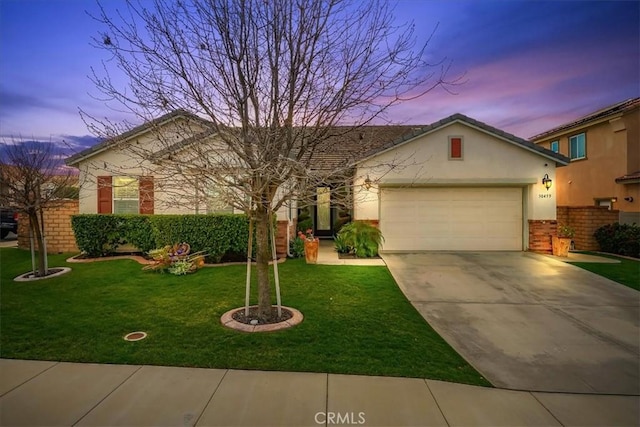 single story home with a garage, a front lawn, stucco siding, and concrete driveway