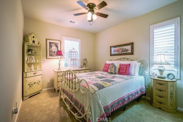 carpeted bedroom with visible vents, baseboards, and ceiling fan