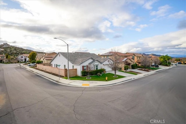 view of street featuring a residential view, sidewalks, street lighting, and curbs