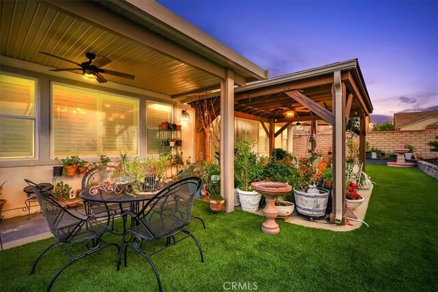 30459 Cowboy Ln, Menifee, CA 92584 - patio terrace at dusk with a ceiling fan, a patio, a gazebo, and outdoor dining area