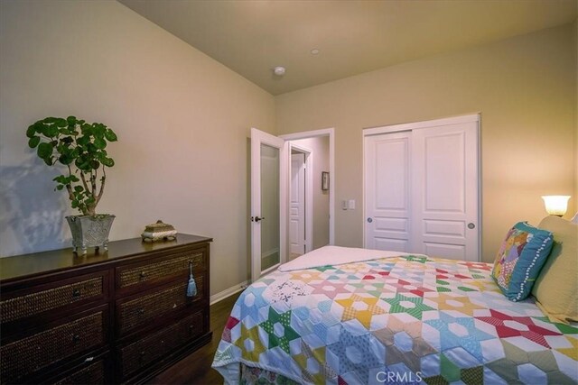 bedroom featuring baseboards, a closet, and wood finished floors