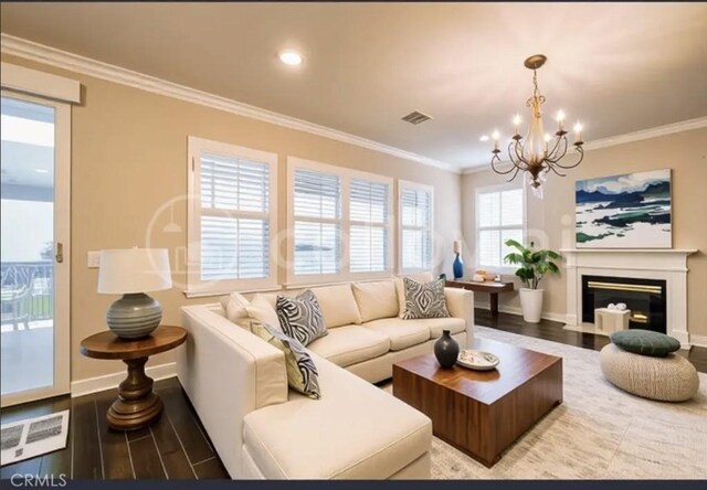 30459 Cowboy Ln, Menifee, CA 92584 - living room with wood finished floors, a chandelier, baseboards, crown molding, and a fireplace with flush hearth