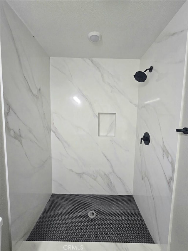 bathroom with a marble finish shower