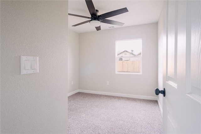 spare room featuring a textured wall, baseboards, ceiling fan, and carpet floors