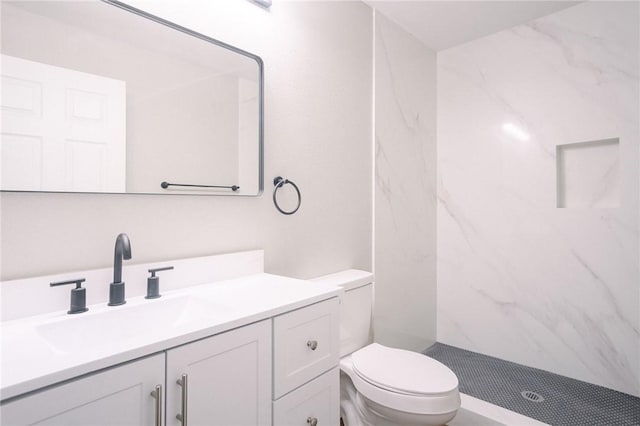 bathroom with a marble finish shower, toilet, and vanity