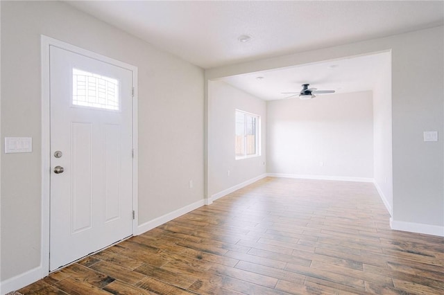 foyer entrance featuring baseboards, ceiling fan, and wood finished floors