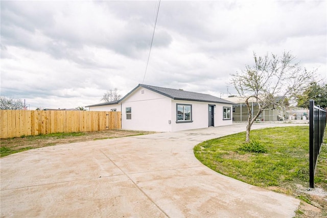 exterior space featuring stucco siding and fence