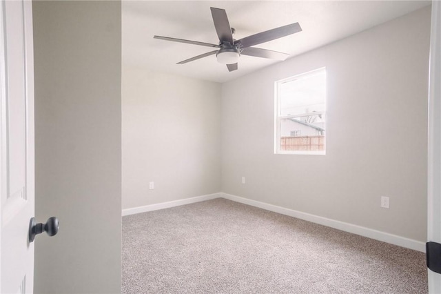 carpeted spare room featuring baseboards and ceiling fan