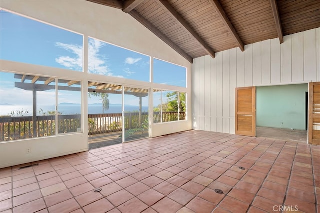 unfurnished sunroom with beam ceiling, a mountain view, and visible vents