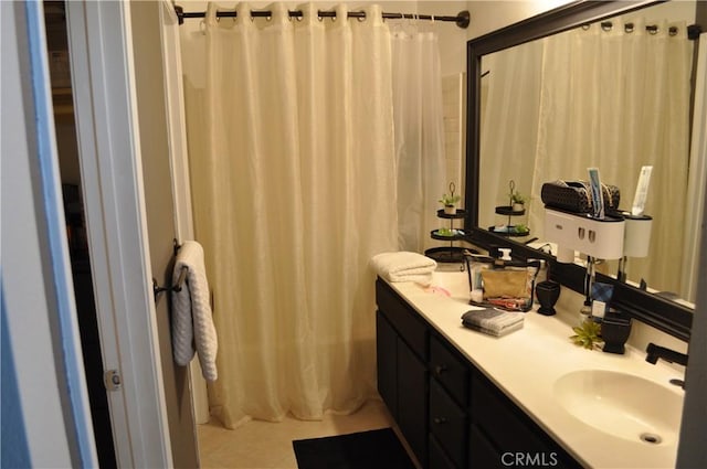 full bathroom featuring a sink, a shower with shower curtain, double vanity, and tile patterned flooring