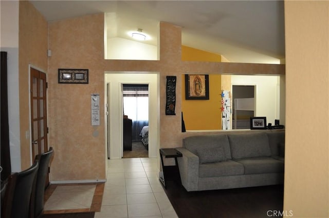 living area featuring tile patterned floors and vaulted ceiling