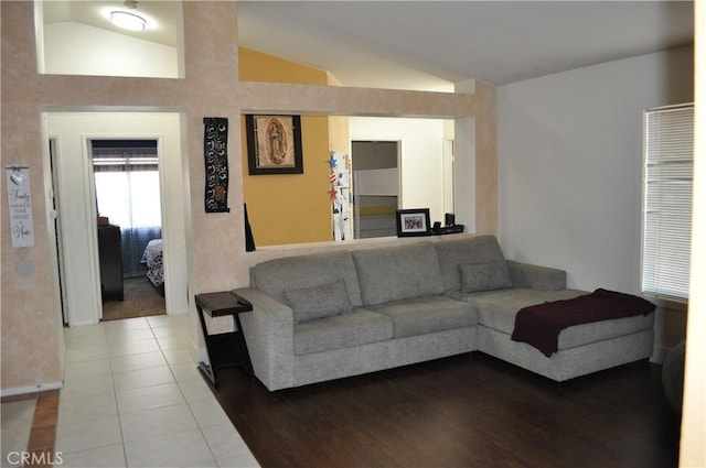 tiled living area featuring lofted ceiling